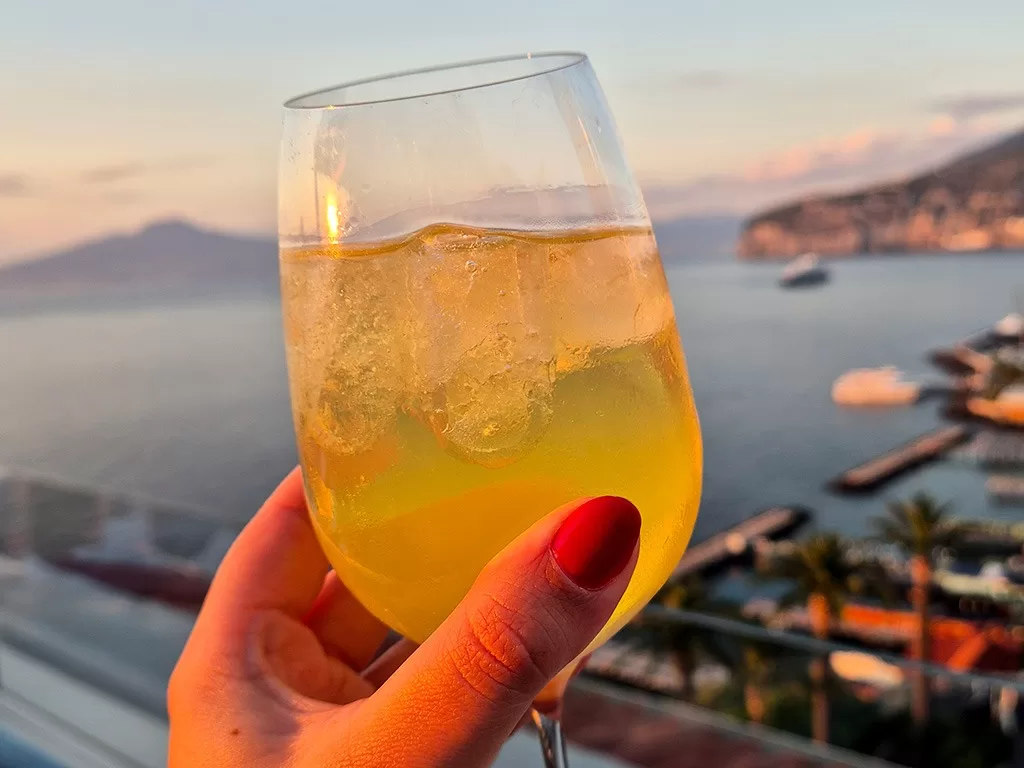 limoncello spritz at sunset with sorrento in the distance