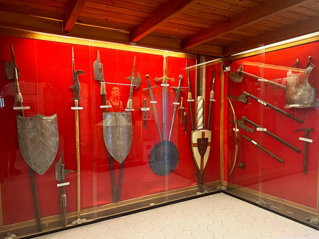 medieval weapons and shields on display in aragonese castle