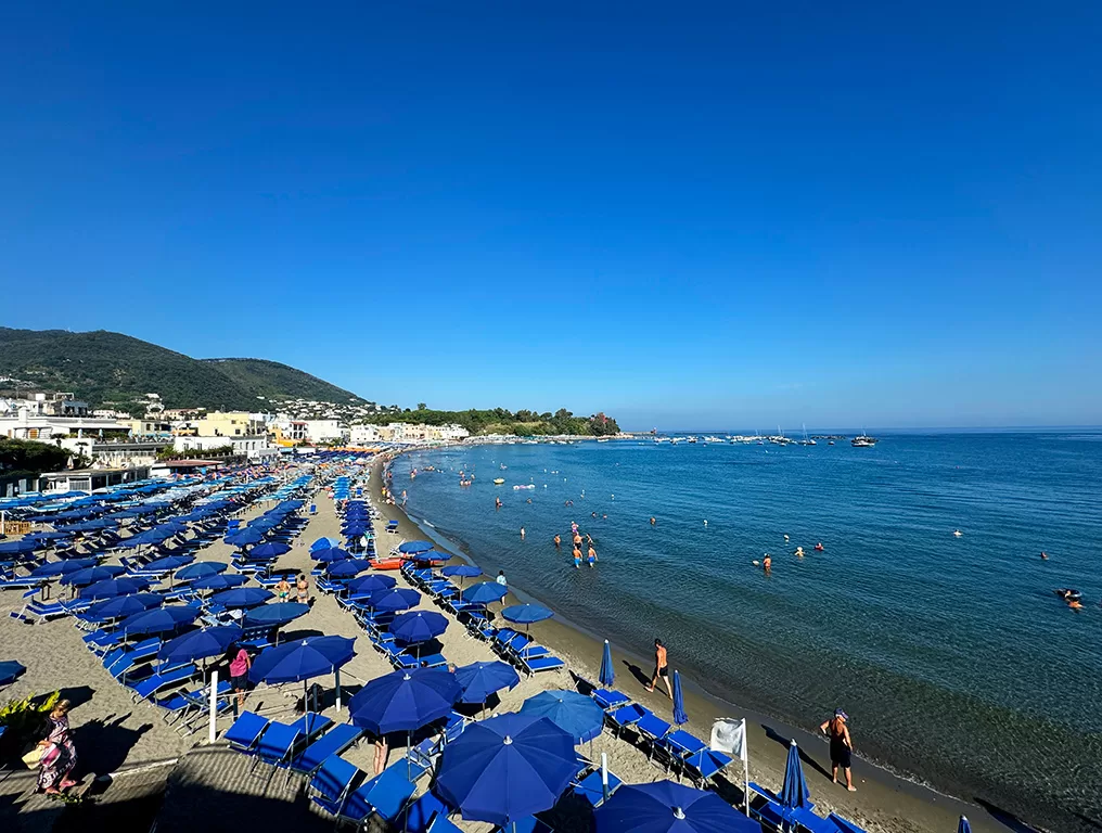 ischia port beach with beds and umbrellas
