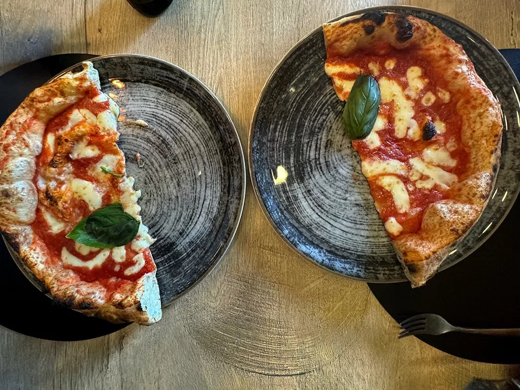 two halves of margarita pizza on two plates