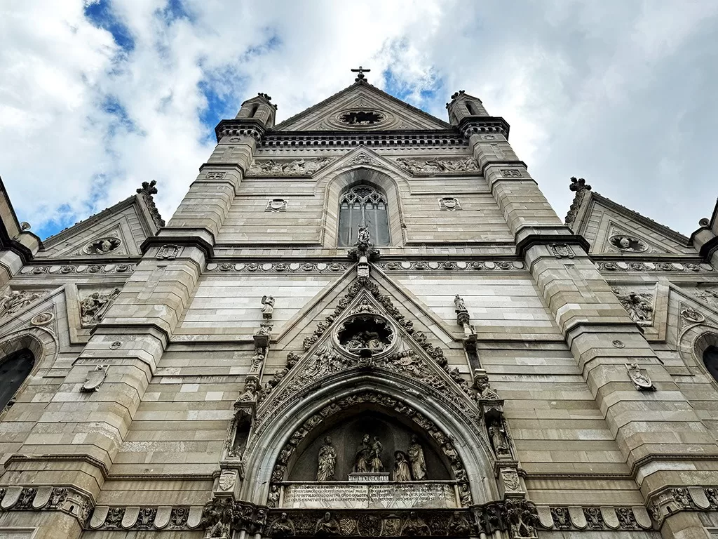 exterior facade of naples cathedral looking straight up from doorway