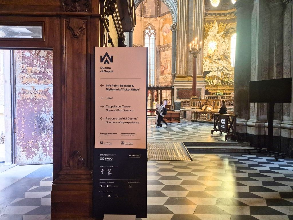 signs inside naples duomo for info point and rooftop tour meeting point