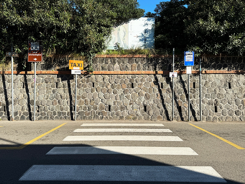 signs for taxi rank and bus stops outside pompeii train station