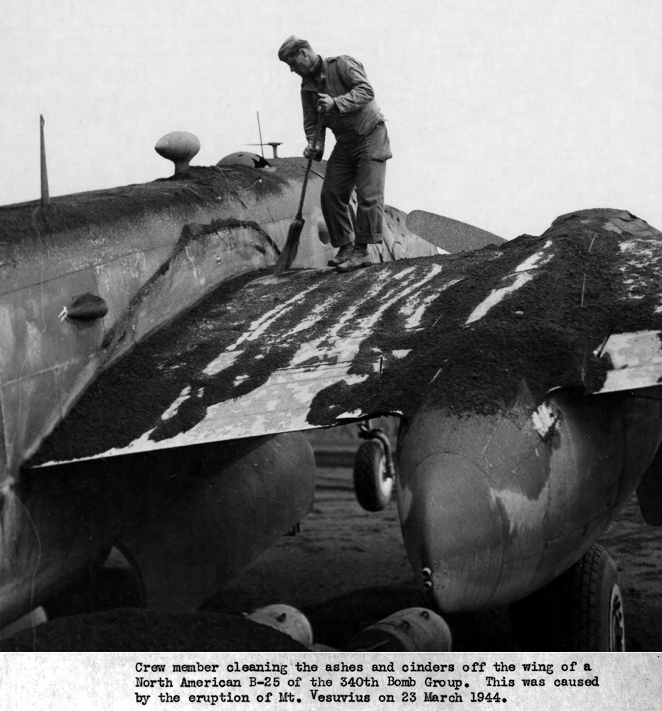 public domain image of US airforce crew cleaning ash off one of their planes after the 1944 eruption of vesuvius