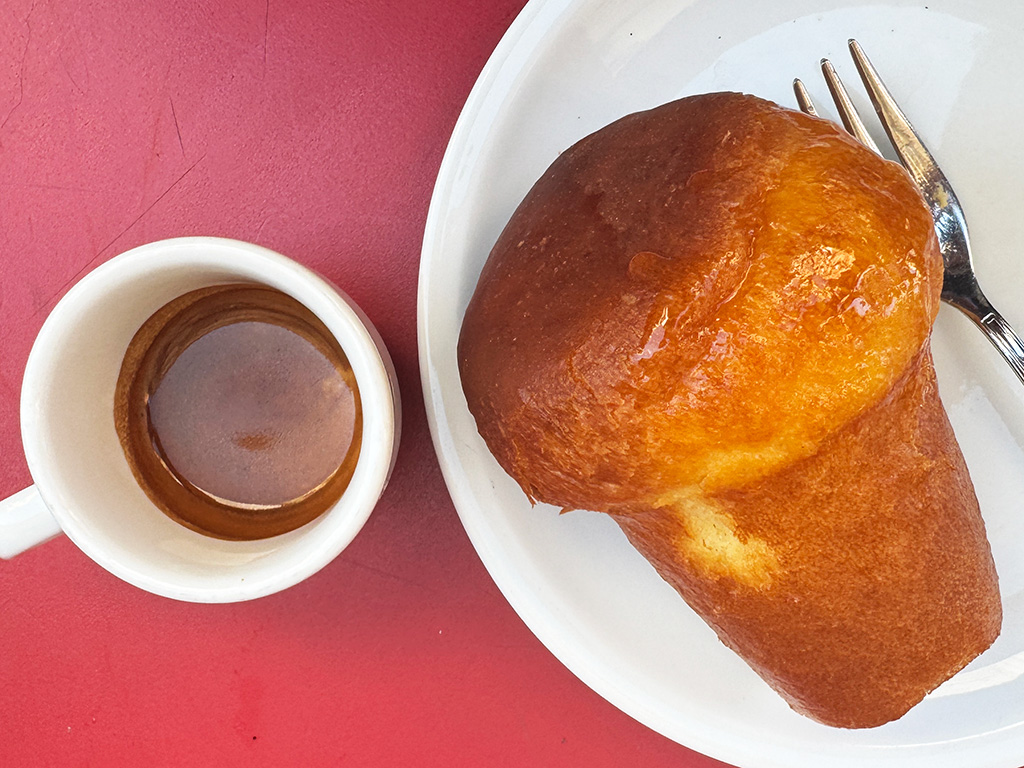 top down view of espresso in a cup and a rhum baba cake