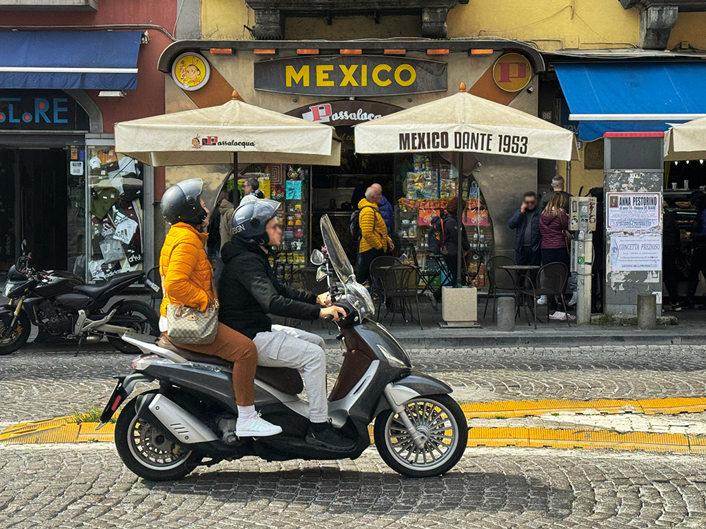 people on a scooter in front of caffe mexico
