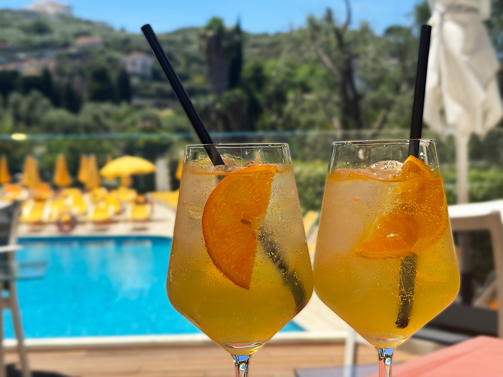 two limoncello spritzes with swimming pool behind