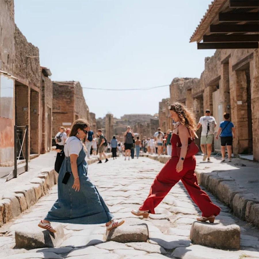 walks of italy pompeii tour image of two women walking across the ancient street